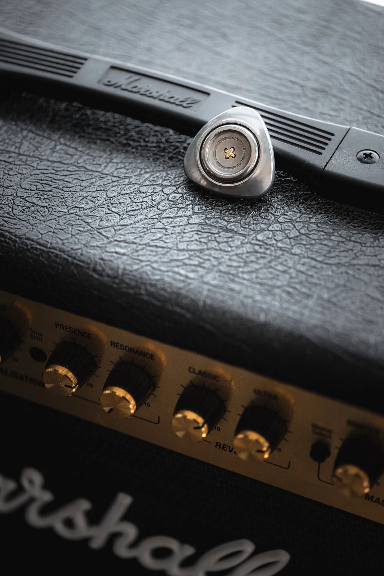 LAUTIE ROC OG stainless steel resting on top of Marshall amp control knobs PRESENCE RESONANCE visible below