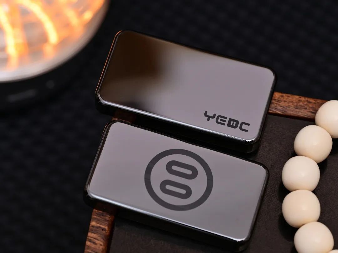 Front and back of a polished black ceramic Zhu Bizi slider