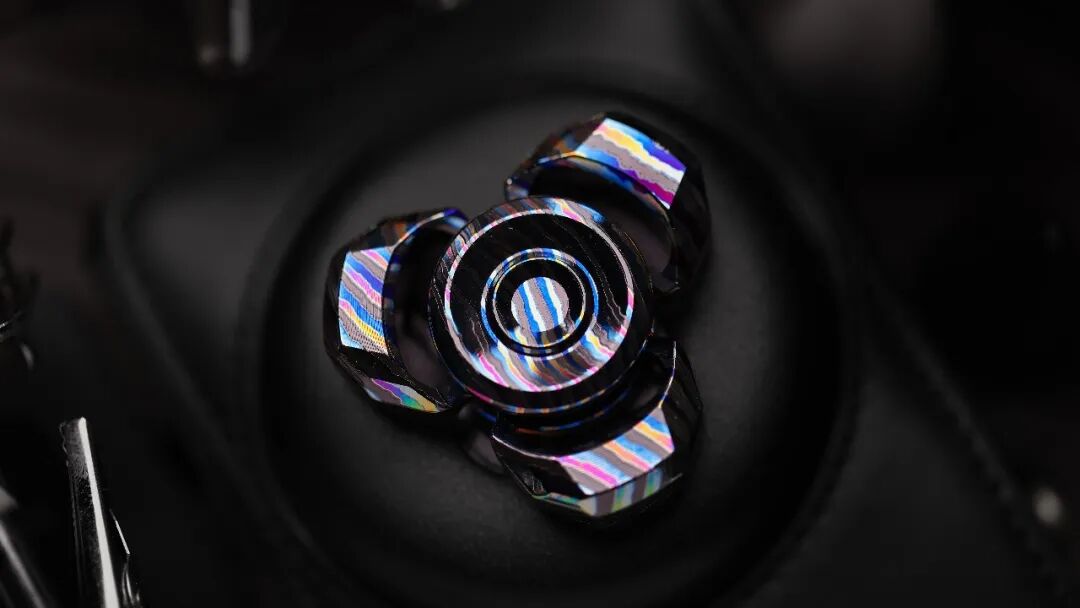 Top view of a four-colour Zircuti Whisper-TRI, showing geometric facets and continuous bands