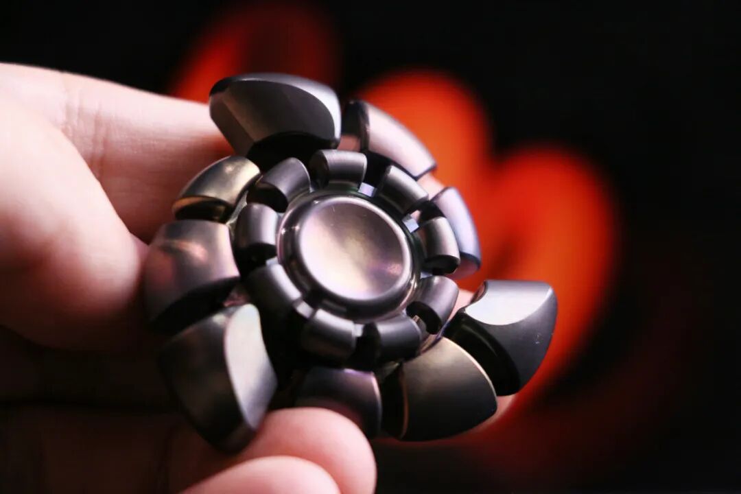 A Huanming Yingwuluo · Longji held in the hand, showing curved blades and a ring of raised forms around the centre.