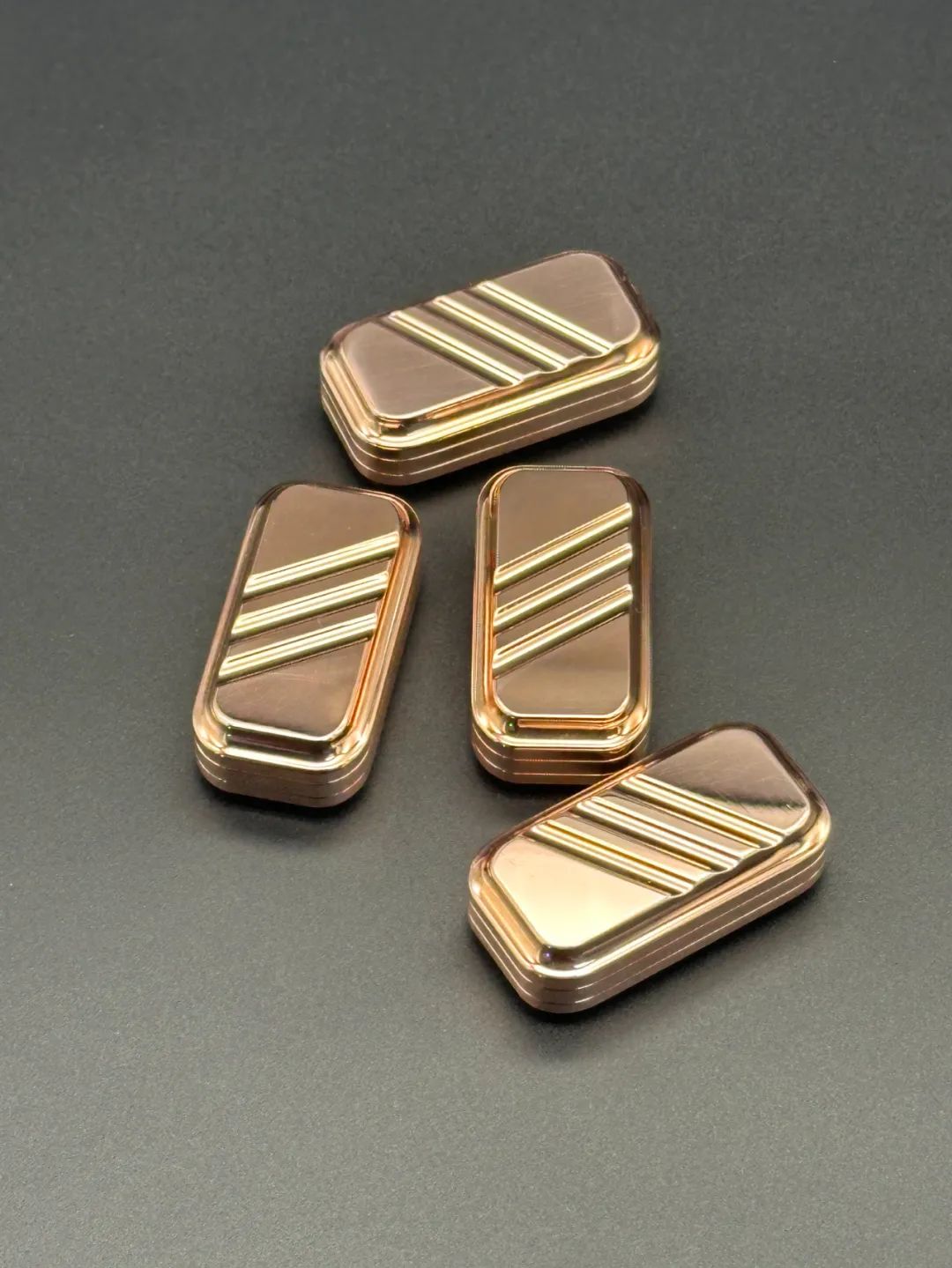 Four polished copper Lucky Candy 2.0 sliders showing diagonal grooves and reflected edge highlights