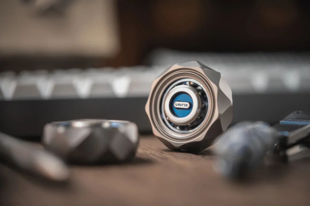 Grey faceted Bit05 spinner with a blue central detail and exposed beads