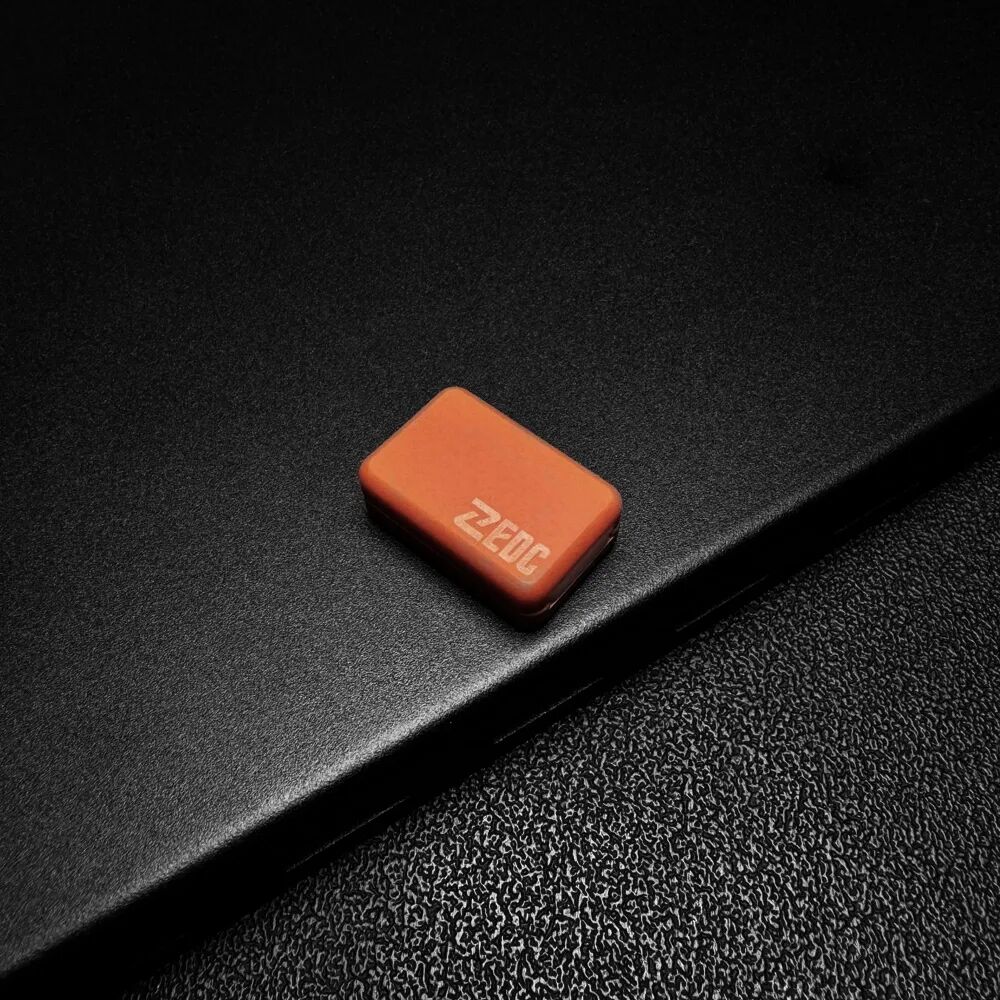 An orange, rounded rectangular Bakelite Xiaoxiaoding slider on a black surface, with pale lettering