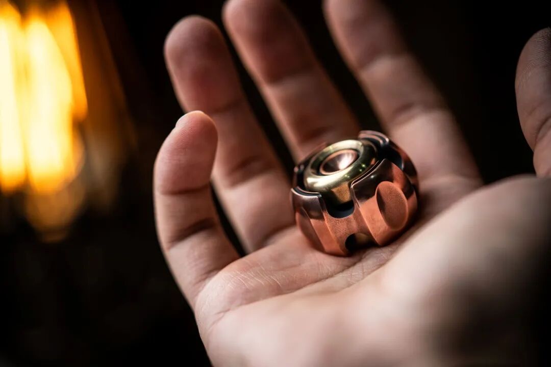 A vintage copper Nano-C in a palm, showing the body recesses and central decorative ring