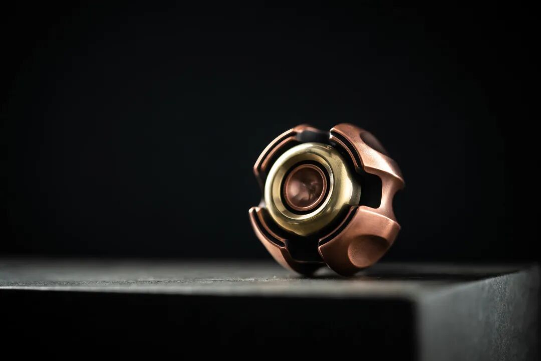 A vintage copper Nano-C standing on a dark surface, its recessed body surrounding a bright decorative ring