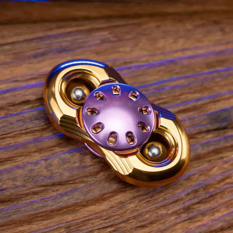 A gold two-arm Jilian with a purple button